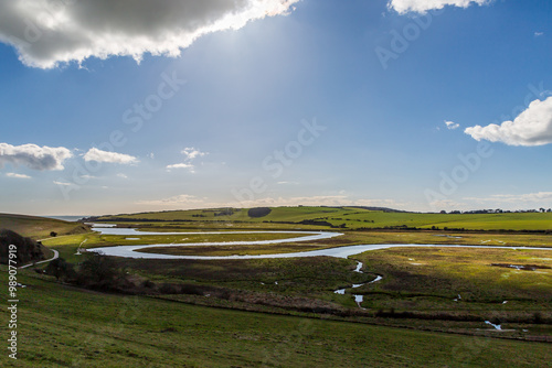 Looking out over the winding Cuckmere River in the South Downs, with a blue sky overhead