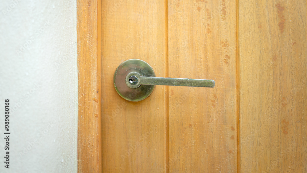 Close-up at luxury designed chrome steel doorknob handle lever of the house's wooden door. Building object with selective focus. Close-up at luxury designed chrome steel doorknob handle lever of the house's wooden door. Building object with selective focus.