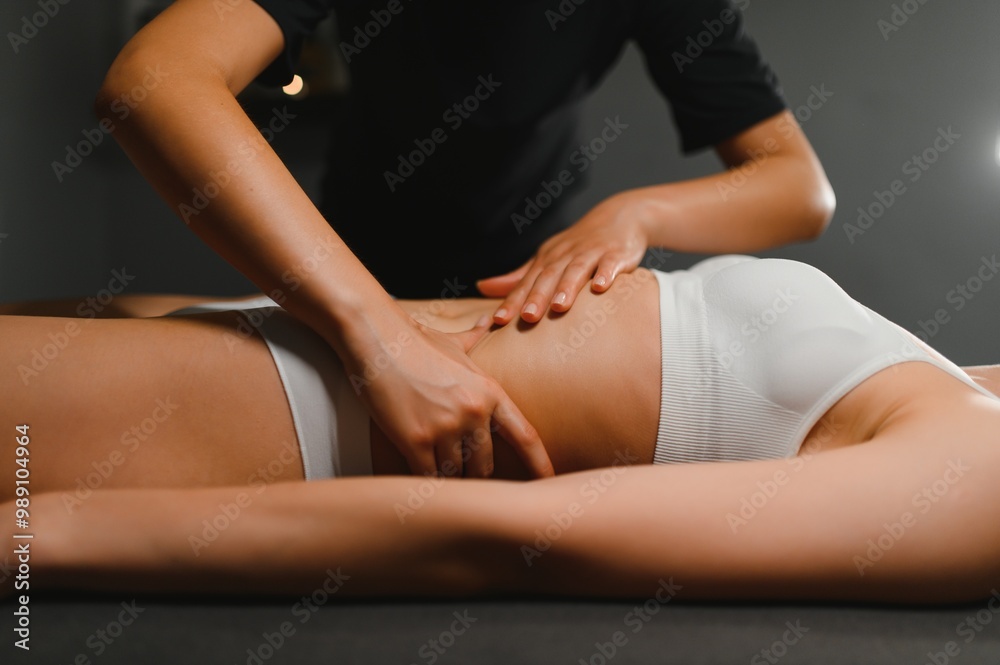 Fototapeta premium A masseuse woman doing an oil massage to woman on the stomach