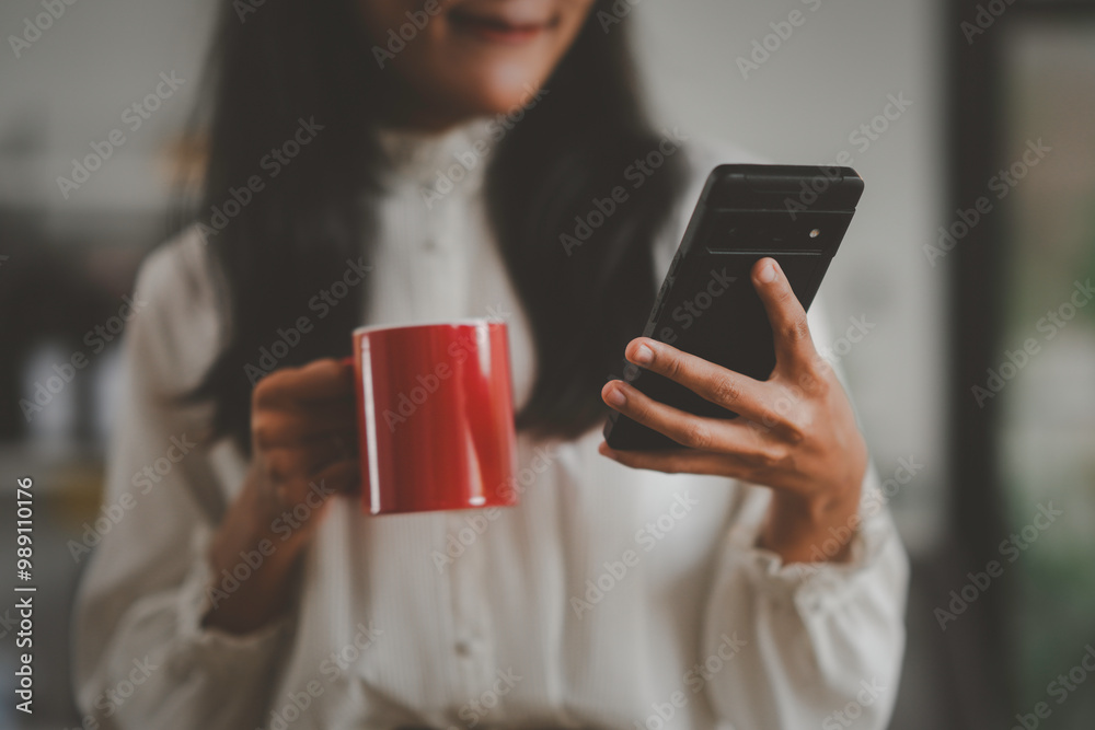 Businesswoman is enjoying a cup of coffee while checking her smartphone during a break Businesswoman is enjoying a cup of coffee while checking her smartphone during a break