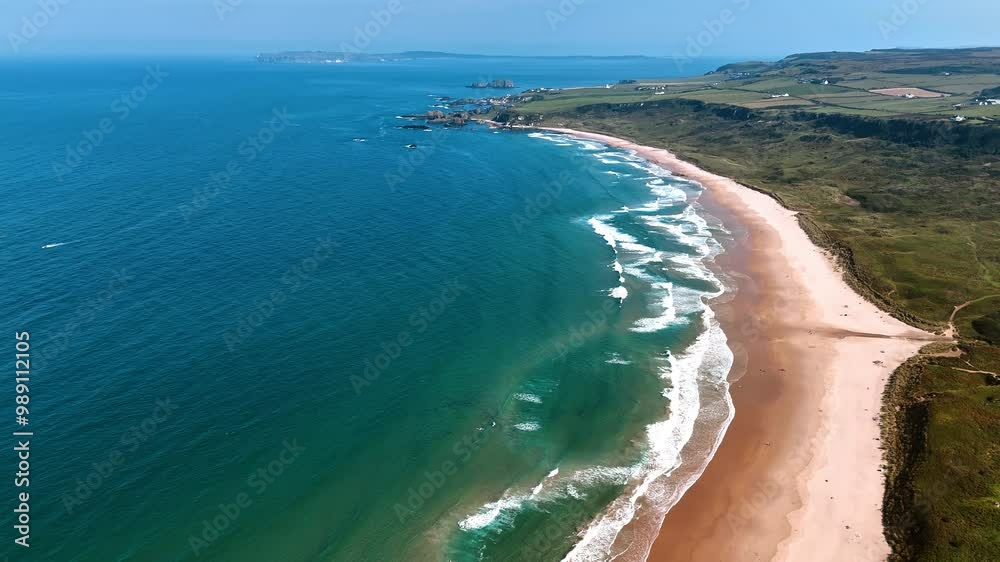 Mesmerizing view of the waves rolling on the sandy beach. Picturesque rocky shore of Ireland from top perspective.