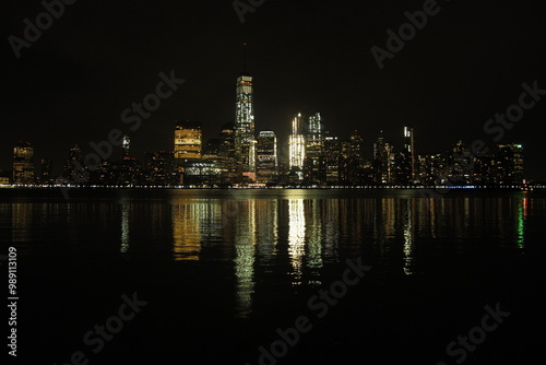 New York City skyline reflecting on the Hudson River at night