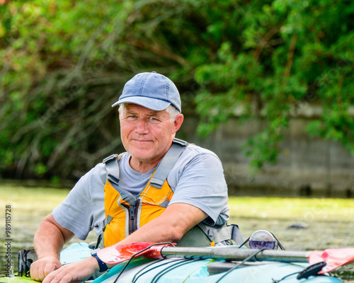 Photography healthy active lifestyle: senior person kayaking on the toronto isdlands an urba
