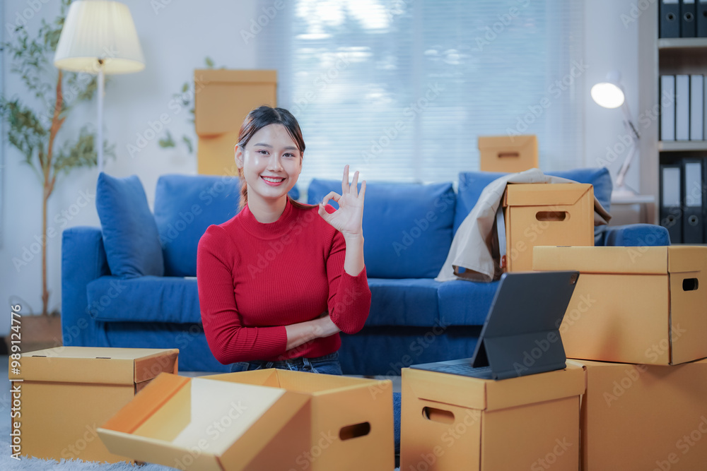 Young entrepreneur is working at home in her startup's online store and is confirming the preparation of an order for shipment