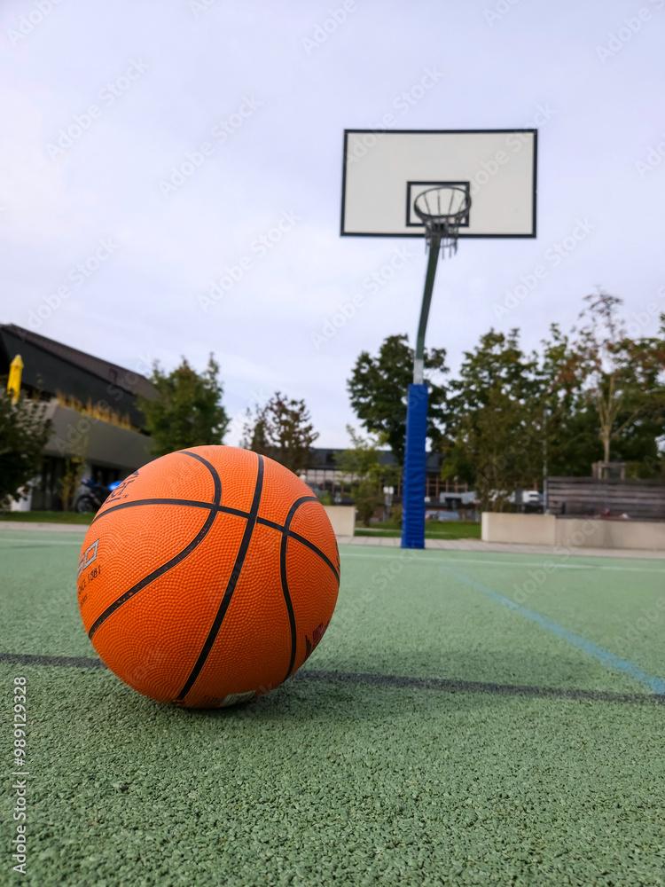 Orange basketball on soft outdoor green sports field, back basketball hoop. High quality photo Orange basketball on soft outdoor green sports field, back basketball hoop. High quality photo