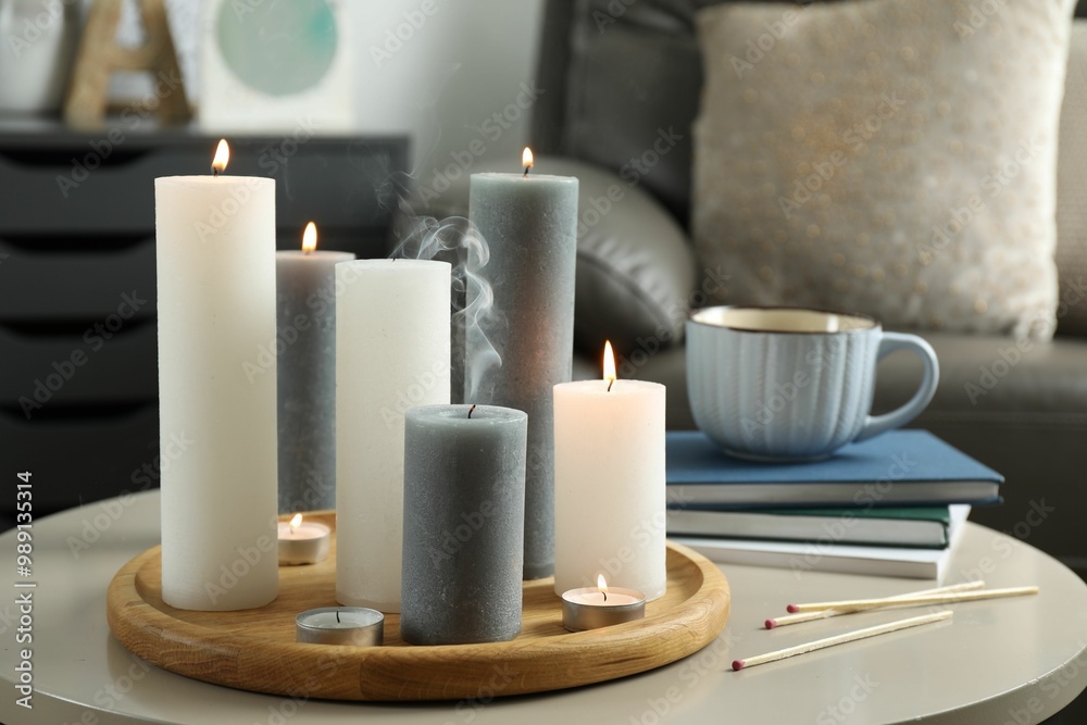 Beautiful burning candles and matches on light table indoors Beautiful burning candles and matches on light table indoors