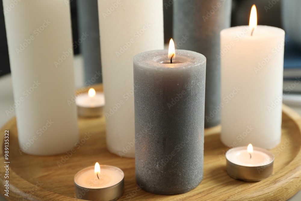 Beautiful burning candles on wooden board, closeup Beautiful burning candles on wooden board, closeup