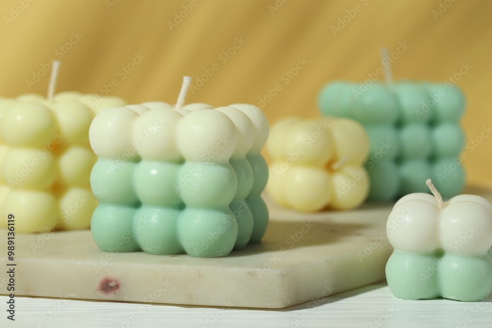 Beautiful bubble candles on white wooden table, closeup Beautiful bubble candles on white wooden table, closeup