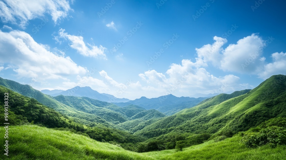 Fototapeta premium Breathtaking panoramic view of lush green hills under a serene blue sky