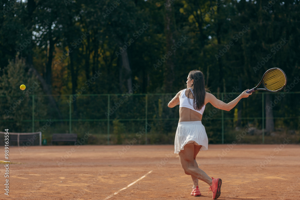 Obraz premium Young woman playing tennis outdoor at summer