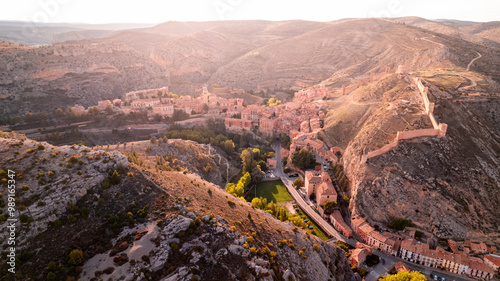 Drone photograph of the castle of Albarracín, crowning the town on its hill. An aerial image showing its fortified structure surrounded by the famous wall and the natural environment.
