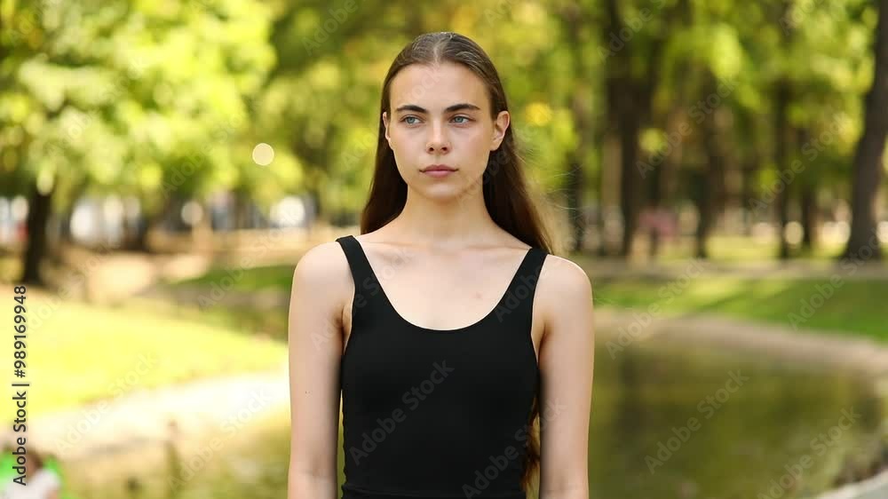 young brunette girl pose for camera in summer park young brunette girl pose for camera in summer park