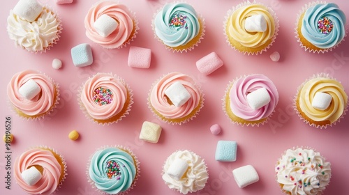 Colorful cupcakes with swirls and marshmallows on a pink background.