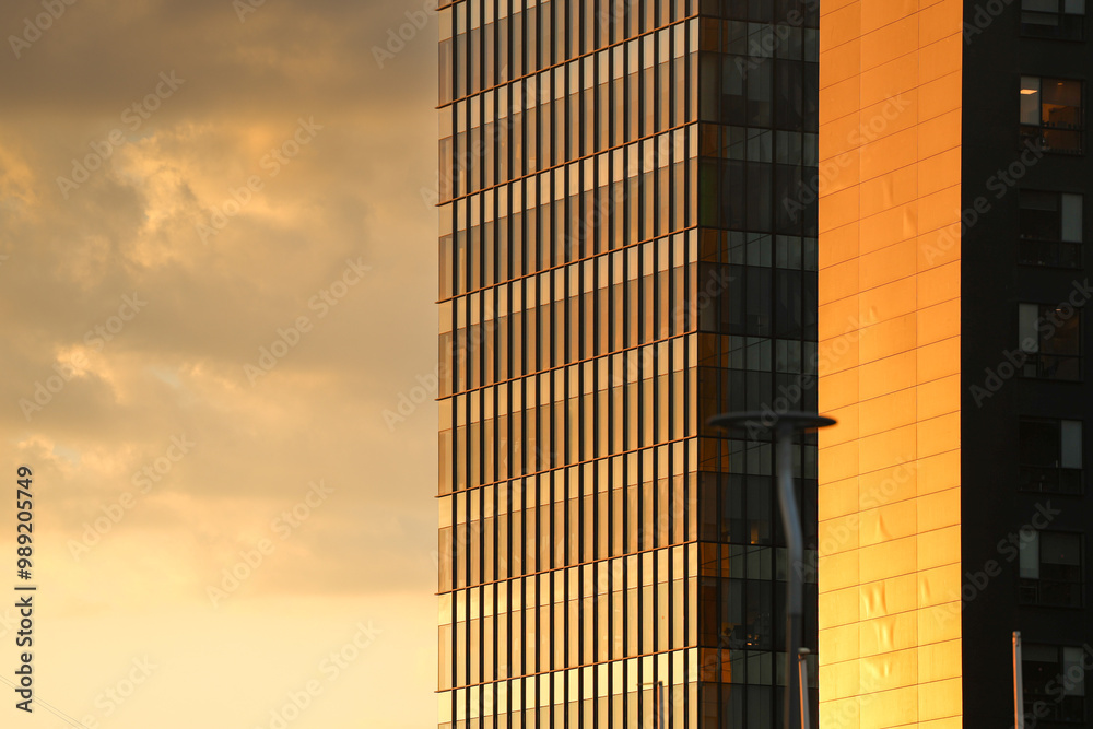 Modern office building. Close up photo with the exterior glass steel facade of an office building places for companies headquarters offices. Corporate concept photo with sunset sky.