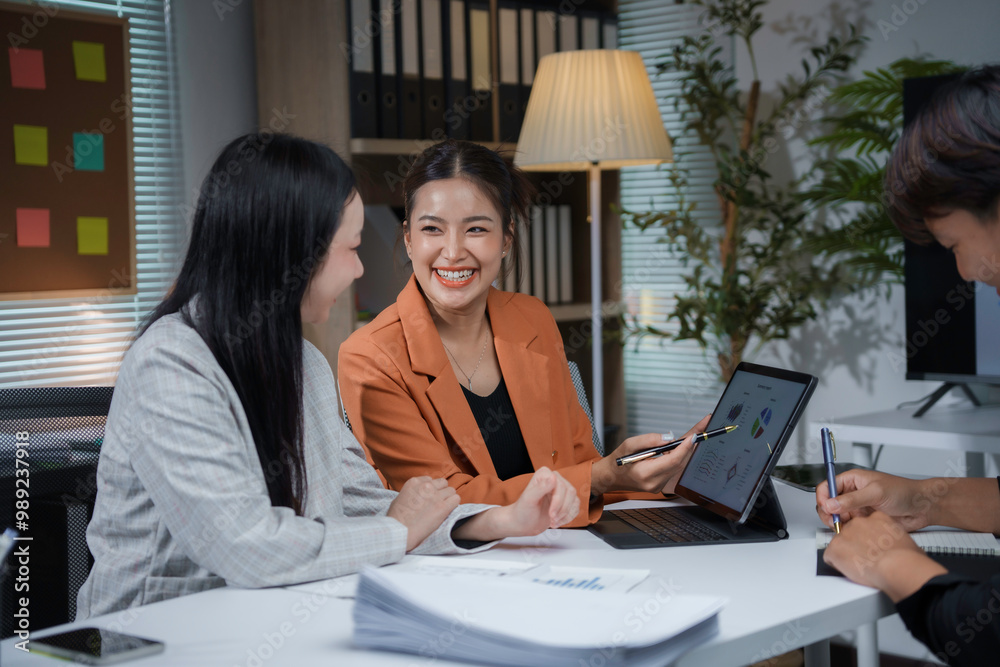 © amnaj - Happy asian businesswoman presenting business report using tablet with colleagues working in the office © amnaj - Happy asian businesswoman presenting business report using tablet with colleagues working in the office