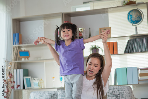 Mother having fun and playing with her daughter at home, family concept