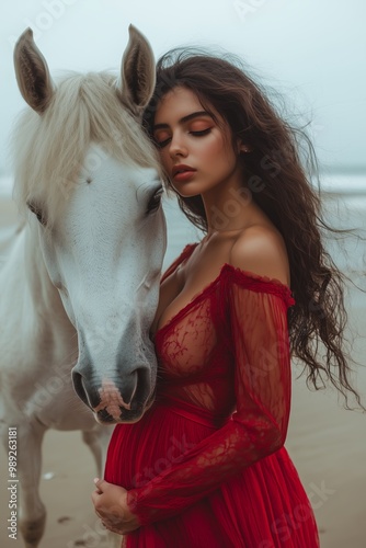 A serene woman in a red dress embraces a white horse on a misty beach, capturing a moment of tranquility.