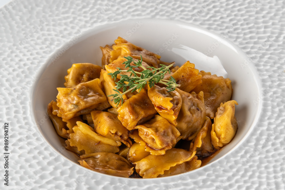 Agnolotti del Plin seasoned with roast sauce, stuffed egg pasta ravioli from the tradition of Piedmont, Italy. Plin in white plate Agnolotti del Plin seasoned with roast sauce, stuffed egg pasta ravioli from the tradition of Piedmont, Italy. Plin in white plate