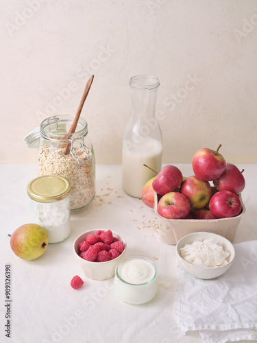 Ingredients for making overnight oats or a porridge bowl. Grains, fruits, berries and dairy products. White background