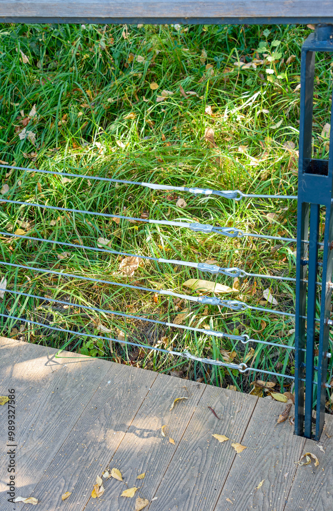 Wooden deck with metal railing and green grass background. Wooden deck with metal railing and green grass background.