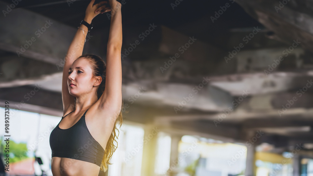 Fototapeta premium Cinematic tone of young attractive fitness woman exercise at gym. Individual sport to fit muscles of body for healthy life concept.