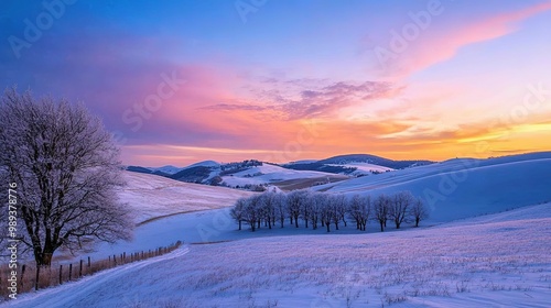 Snow-covered mountain landscape during sunset with vibrant colors illuminating the sky in a serene winter setting