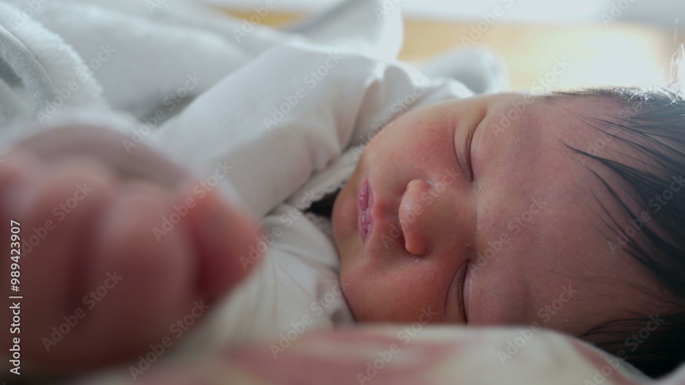 Newborn baby grimacing in sleep, close-up of face showing discomfort, likely passing gas, capturing the natural and candid moments of early life Newborn baby grimacing in sleep, close-up of face showing discomfort, likely passing gas, capturing the natural and candid moments of early life