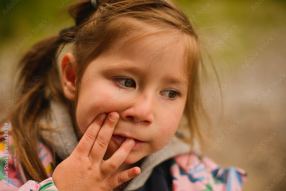 Portrait of a small girl with ponytails in a jacket. Grimaces. Emotions. Autumn Portrait of a small girl with ponytails in a jacket. Grimaces. Emotions. Autumn