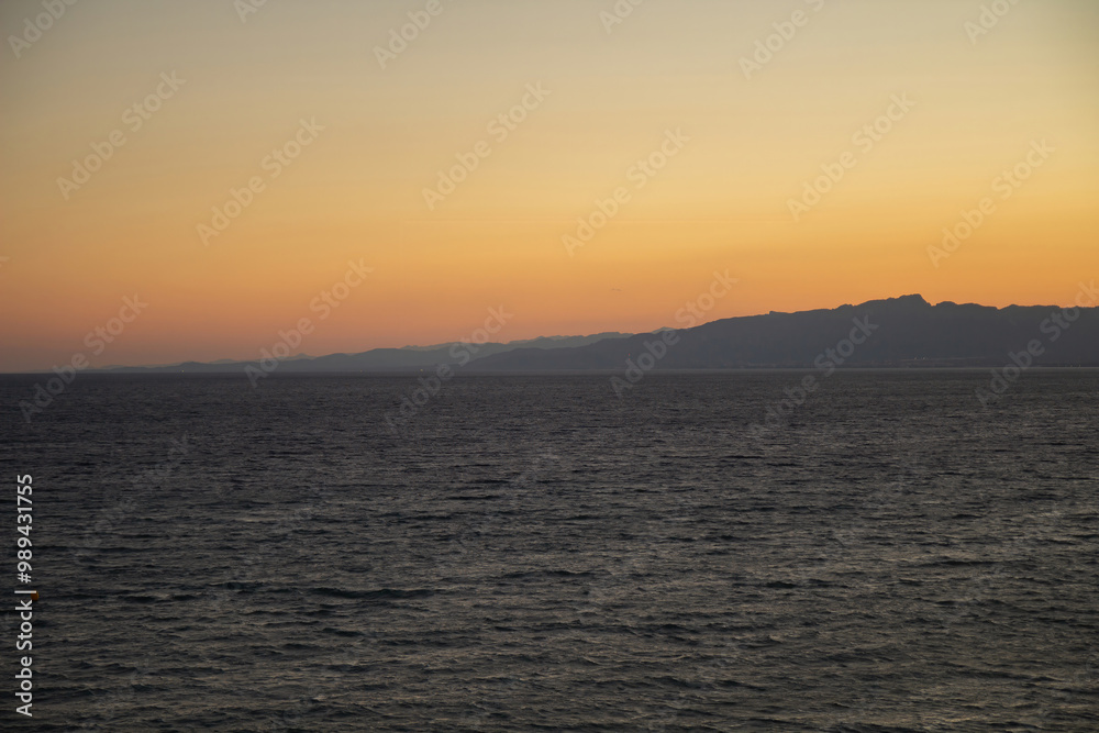 Colorful sunset over spanish coastline. Seascape with sun rays in the evening.