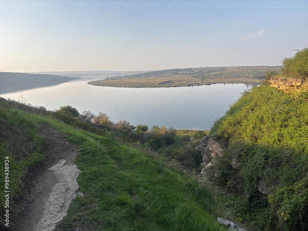 The bends of the Dniester River into the heights of sheer cliffs. Rocky area on the river bank. Deep ravine near the water The bends of the Dniester River into the heights of sheer cliffs. Rocky area on the river bank. Deep ravine near the water