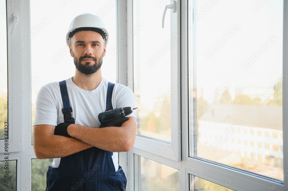 Construction worker installing window in house. Handyman fixing the window with screwdriver