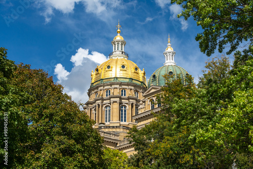 The Iowa state Capitol building on a hot late summer day with blue skies and clouds.  Des Moines, Iowa, USA.