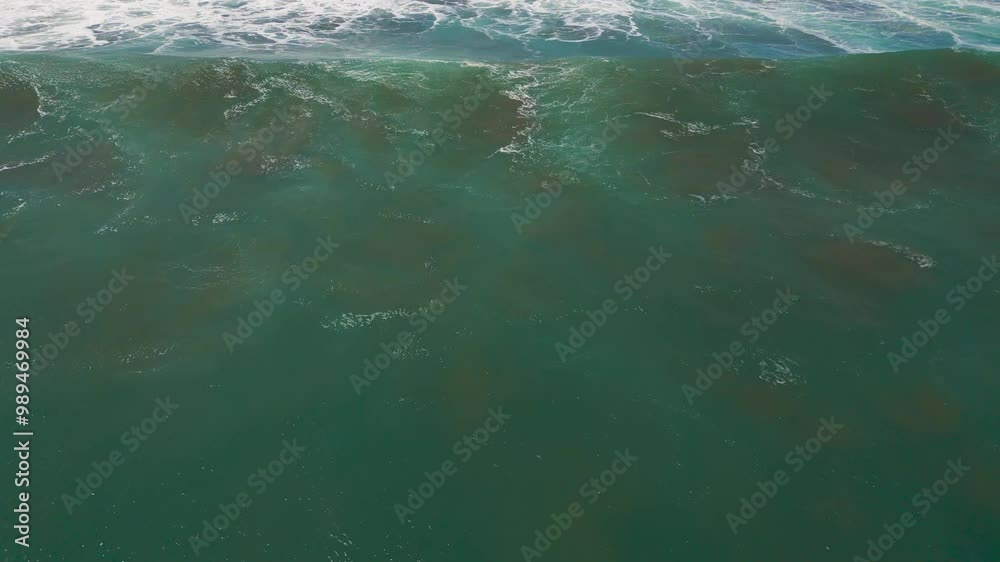 Aerial view of the sea with gentle waves in Seminyak, Bali.