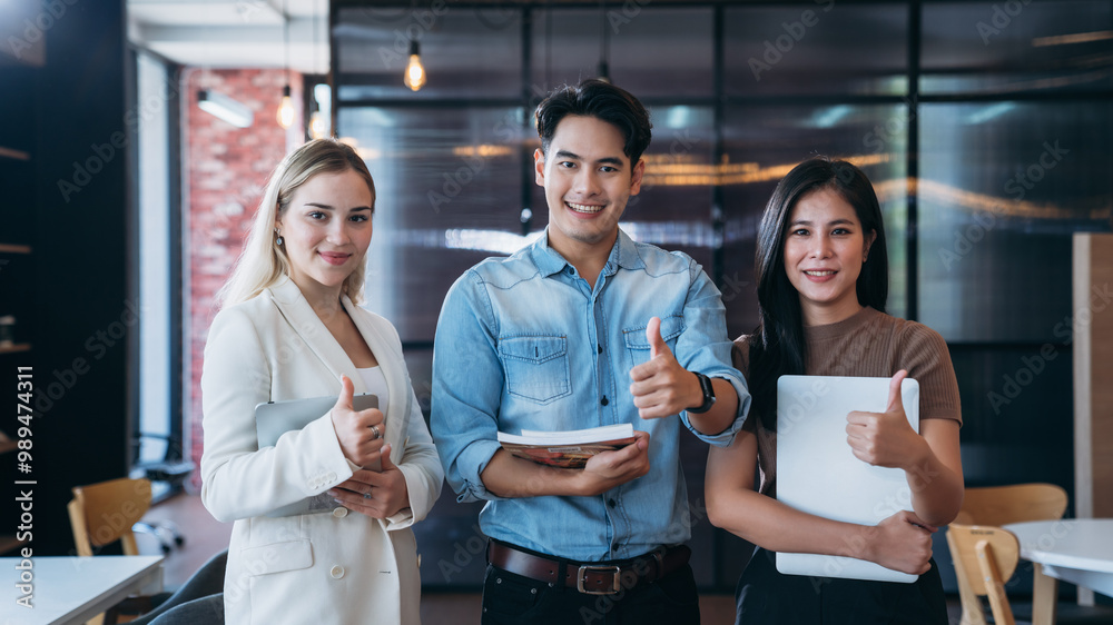 Three people are standing in a room, one of them is holding a laptop Three people are standing in a room, one of them is holding a laptop