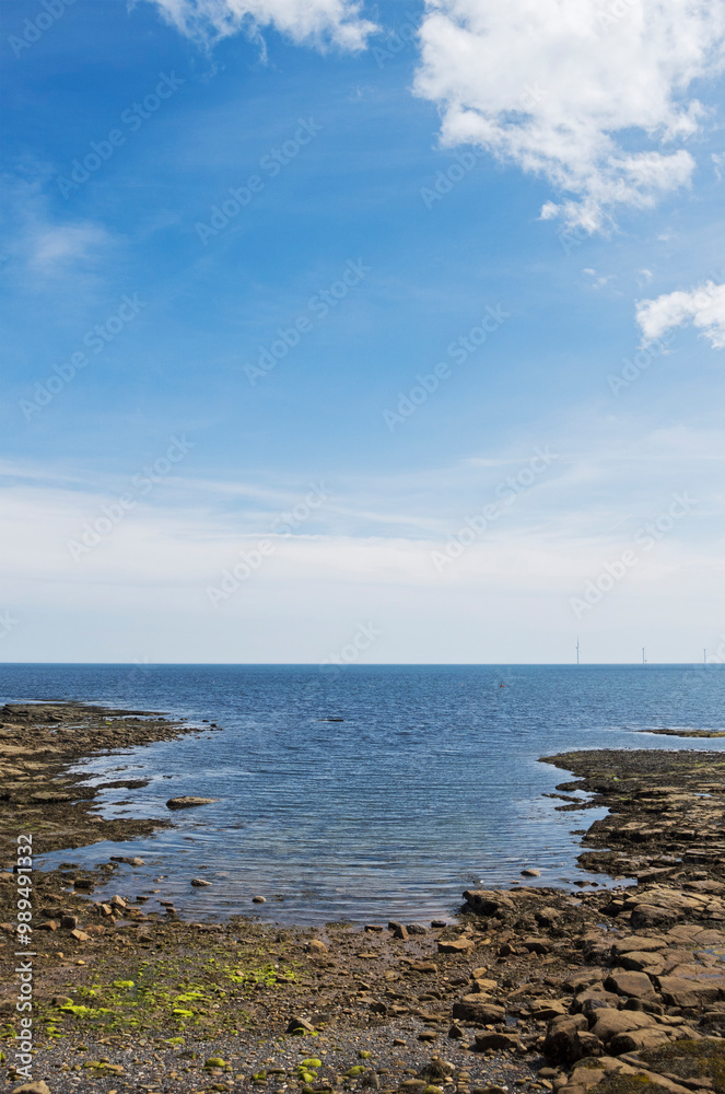 Seascape with rocks, windfarm and copyspace