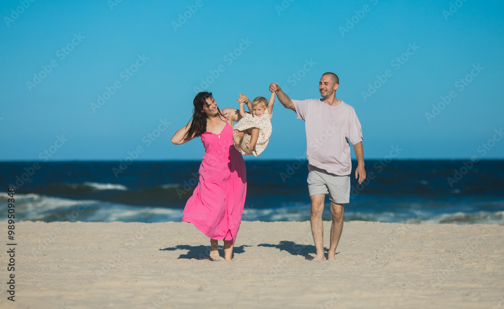 Happy Family swinging and spinning cute daughter in circles by the arms at the beach. Playful, energetic and joyful kid having fun Happy Family swinging and spinning cute daughter in circles by the arms at the beach. Playful, energetic and joyful kid having fun