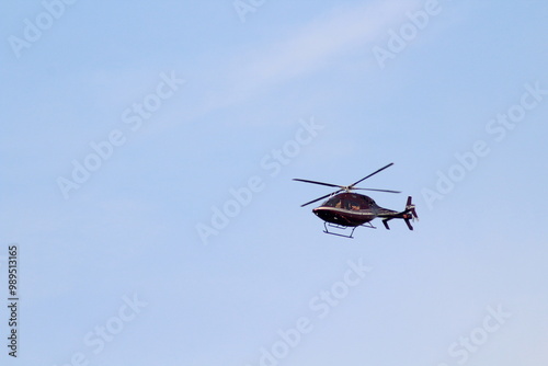 Red helicopter in flight on blue sky. Red helicopter. Red helicopter with text kings isolated on a blue sky background