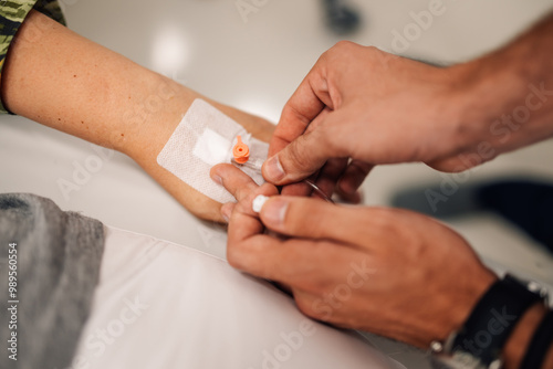 Healthcare professional inserting IV catheter into patient’s arm.