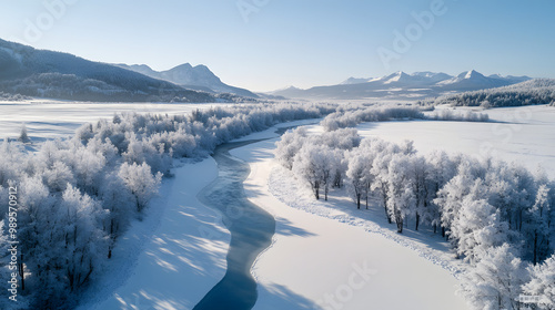 A frozen river winding through a snow-covered valley with frosted trees lining the banks and mountains rising in the distance under a clear sky.