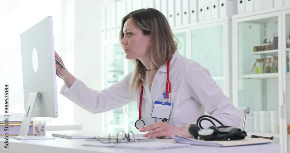 Focused woman doctor presses keys on keyboard typing report at workplace in hospital. Blonde female medic engages in work process inputting data Focused woman doctor presses keys on keyboard typing report at workplace in hospital. Blonde female medic engages in work process inputting data