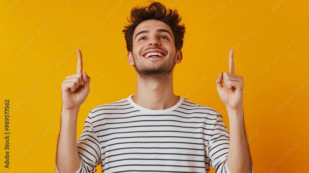 Photo of attractive guy hold hands fingers direct up empty space excited good mood sales person wear striped t-shirt isolated bright orange color background. Photo of attractive guy hold hands fingers direct up empty space excited good mood sales person wear striped t-shirt isolated bright orange color background.