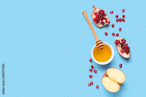 Bowl of honey with pomegranate and apple for Rosh Hashanah celebration (Jewish New Year) on grey background