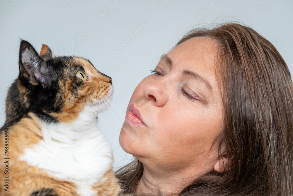 woman holding pet, adult dark domestic female cat close-up, looks around, keeping four-legged pets, veterinarian, love for animals, pet care, daily life woman holding pet, adult dark domestic female cat close-up, looks around, keeping four-legged pets, veterinarian, love for animals, pet care, daily life