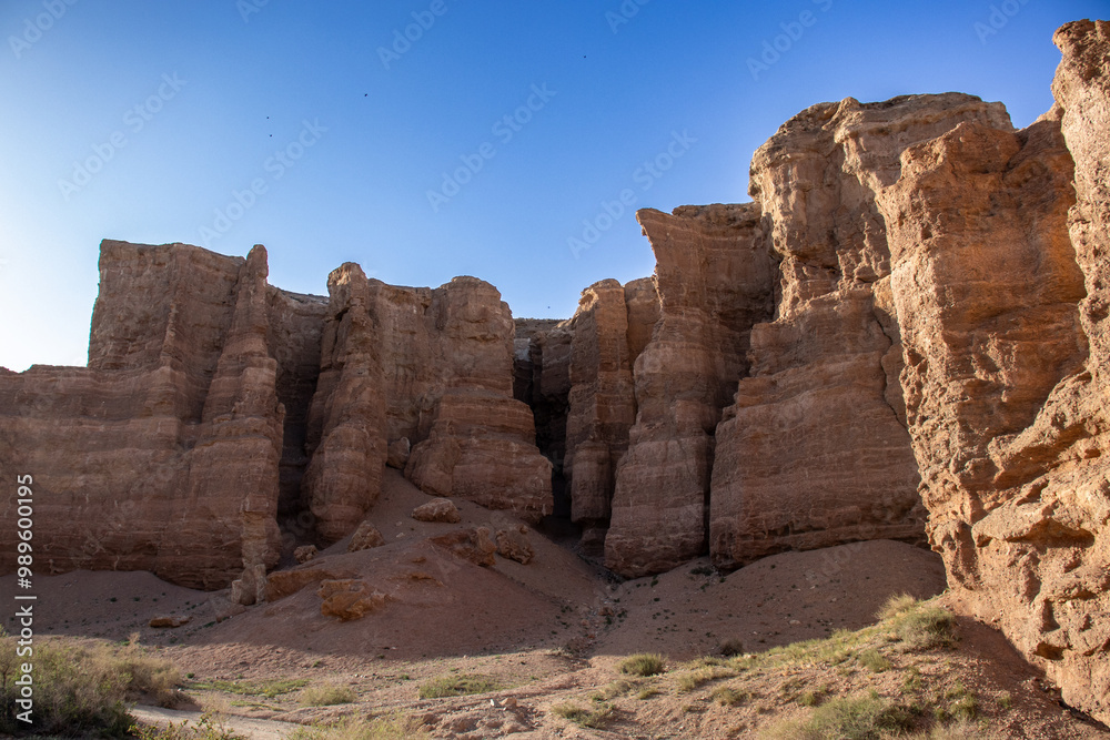 A stunning Charyn canyon in the desert beneath a bright blue sky A stunning Charyn canyon in the desert beneath a bright blue sky