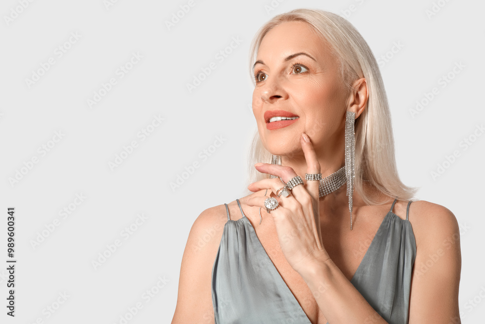 Fashionable mature woman in beautiful jewelry on white background Fashionable mature woman in beautiful jewelry on white background