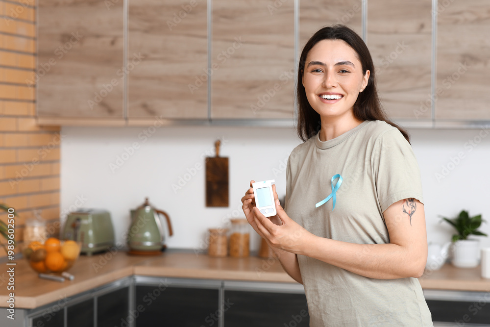 Diabetic young woman with blue awareness ribbon and glucometer in kitchen Diabetic young woman with blue awareness ribbon and glucometer in kitchen