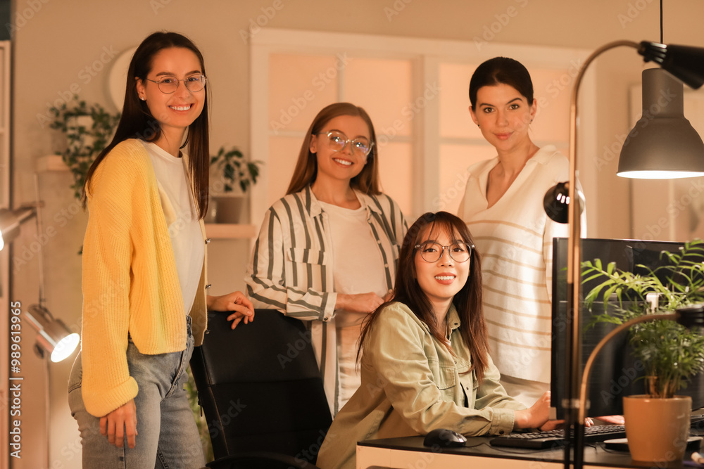 Team of female programmers working in office at night Team of female programmers working in office at night