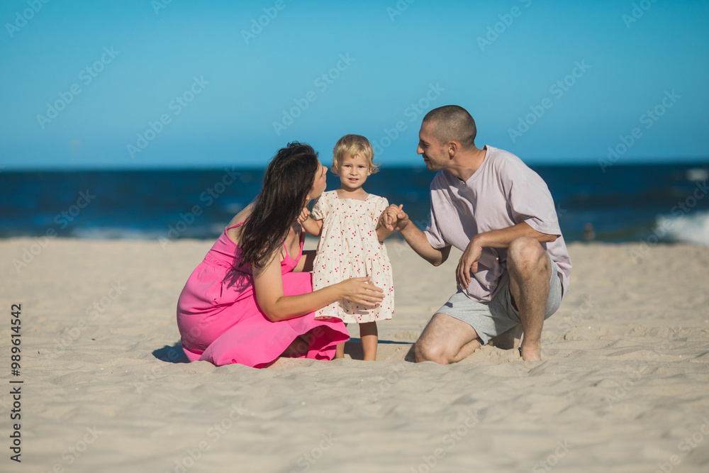 Happy family at the ocean. Parents kiss her daughter Happy family at the ocean. Parents kiss her daughter