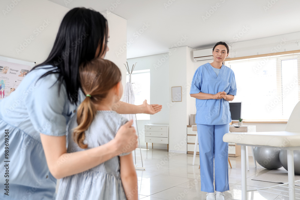 Mother and female osteopath working with little patient in clinic Mother and female osteopath working with little patient in clinic