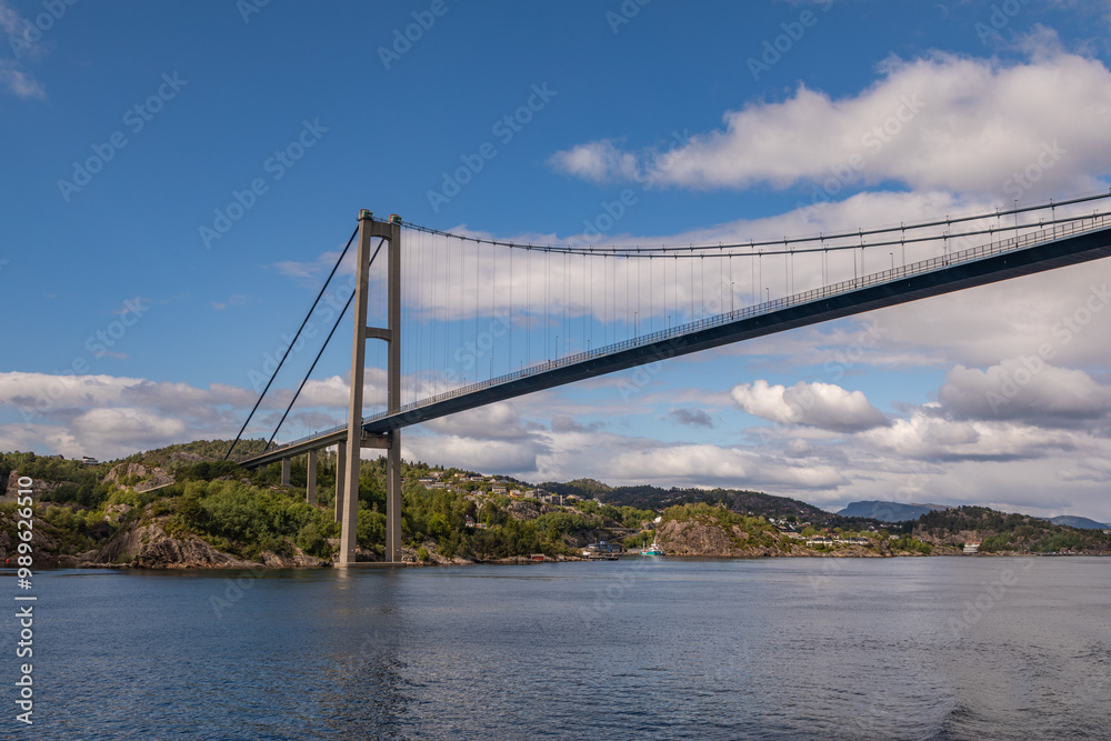 Naklejka premium Passing Under the Askøy Suspension Bridge Across the Byfjorden, From the deck of a cruise ship leaving Bergen, Norway in Summer